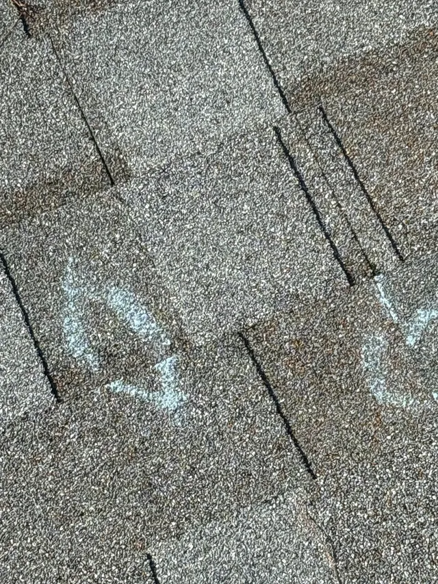 Close view of marked shingles during inspection at the Foxpoint Drive project in Maryland Heights
